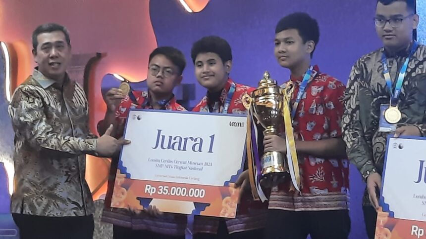 Kepala Suku Dinas Kebudayaan Kota Administrasi Jakarta Timur, Berkah Shadaya memberikan piala kepada para peserta juara 1 Lomba Cerdas Cermat Museum (LCCM) Tingkat Nasional 2023 diraih pelajar SMPN 255 Jakarta Timur mewakili Provinsi DKI Jakarta, Jumat (13/10). Foto: Ist