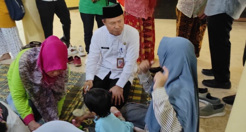 Kepala Bagian Kesejahteraan Rakyat Kota Administrasi Jakarta Timur, Rohmad ikut melakukan Pemberian Makanan Tambahan (PMT) kepada 13 anak terindikasi stunting di Gedung Serbaguna RW 03 Kelurahan Munjul, Kecamatan Cipayung Jakarta Timur, Jumat (13/10). Foto: Ist