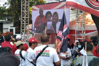 Massa pendukung pasangan capres-cawapres, Ganjar-Mahfud MD mendengarkan pidato Ketua Umum PDIP, Megawati lewat videotron di depan pagar gedung KPU RI.(foto Sofian/ipol.id)