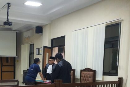 Terdakwa saat berkonsultasi dengan kuasa hukumnya di sela sela sidang pemeriksaan saksi di PN Balikpapan.
