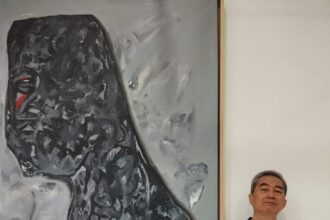 Tjahjadi Hartono dan salah satu lukisan abstraknya. Foto: Ist