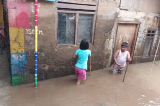 Anak-anak bermain air di kawasan Kebon Pala, RW 04 dan RW 05, Kampung Melayu, Jatinegara, Jakarta Timur yang terendam banjir yang disebabkan luapan Sungai Ciliwung, Minggu (5/11). Foto: Joesvicar Iqbal/ipol.id