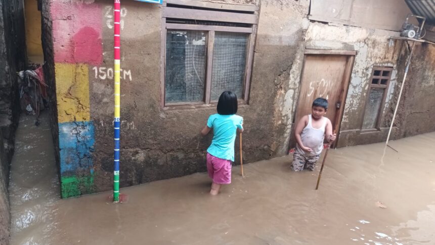 Anak-anak bermain air di kawasan Kebon Pala, RW 04 dan RW 05, Kampung Melayu, Jatinegara, Jakarta Timur yang terendam banjir yang disebabkan luapan Sungai Ciliwung, Minggu (5/11). Foto: Joesvicar Iqbal/ipol.id