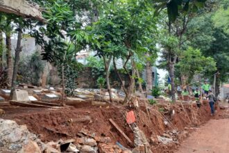 Sejumlah petugas Sudin Pertamanan dan Hutan Kota Jakarta Timur melakukan perbaikan tembok pembatas Taman Pemakaman Umum (TPU) Cibubur II, RT 15/RW 05, Kelurahan Cibubur, Kecamatan Ciracas, yang longsor, Senin (6/11) siang. Foto: Joesvicar Iqbal/ipol.id