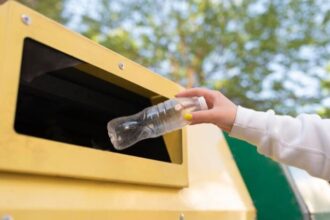 Ilustrasi - Warga membuang botol bekas air mineral ke dalam gerobak sampah untuk menjaga lingkungan tetap bersih. Foto: Freepik