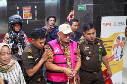 Tersangka AP selaku Direktur Operasional PT Inovasi Global Solusindo saat digelandang ke mobil tahanan.