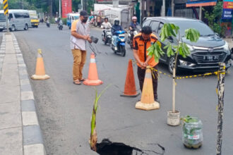 Keadaan saat aspal Jalan Raya Bogor, Kelurahan Susukan, Kecamatan Ciracas, yang ambles sebelum diperbaiki sejumlah petugas Sudin SDA dan Sudin Bina Marga Jakarta Timur, Selasa (21/11). Petugas Satpol PP dan PPSU mengatur arus lalu lintas serta memasang rambu. Foto: Ist