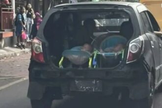 Pengendara letawakn 2 anak dibagasi mobil saat berjalan di Solo. Foto: IG, @undercover (tangkap layar)