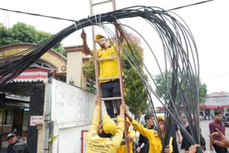 Sejumlah petugas Suku Dinas Bina Marga Jakarta Timur melakukan penataan kabel udara sepanjang 1,5 kilometer (km) yang acak-acakan di Jalan Pahlawan Revolusi, Pondok Bambu, Duren Sawit, Kamis (23/11) siang. Foto: Ist