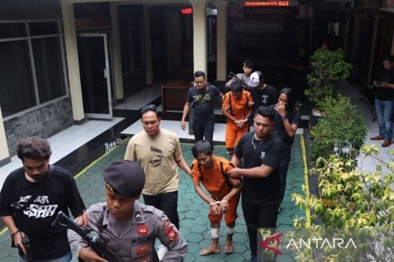 Personel Satreskrim Polres Sukabumi Kota saat menggiring dua pemuda yang diduga pelaku pembunuhan sopir taksi daring. Foto: ANTARA
