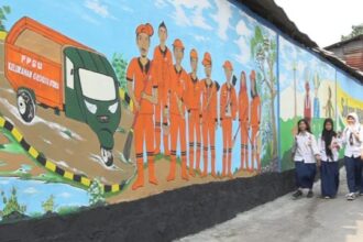 Para pelajar SMP merasa nyaman berjalan kaki melintasi tembok yang dilukis mural oleh petugas penanganan prasarana dan sarana umum (PPSU) di Jalan Inspeksi Kali Grogol, RT 001/RW 005, Kelurahan Grogol Utara, Kecamatan Kebayoran Lama, Jakarta Selatan, Selasa (12/12).