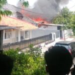 Warga menyaksikan api melumat satu unit rumah di Jalan Rantai Timah, Kelurahan Tengah, Kecamatan Kramat Jati, Jakarta Timur, pada Kamis (21/12). Asap pekat hitam membumbung tinggi ke udara. Foto: Ist
