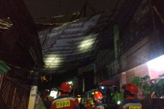 Sejumlah petugas Sudin Penanggulangan Kebakaran dan Penyelamatan Jakarta Timur (Jaktim) mengevakuasi atap rumah warga yang menyangkut pada unit rumah lain di Jalan Cimerak Tengah, Kelurahan/Kecamatan Duren Sawit, Jakarta Timur, Senin (25/12) malam. Foto: Damkar Jaktim