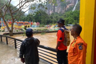Personel Badan Penanggulangan Bencana Daerah (BPBD) Lima Puluh Kota meninjau lokasi banjir yang merendam area wisata Lembah Harau pada Selasa (26/12).