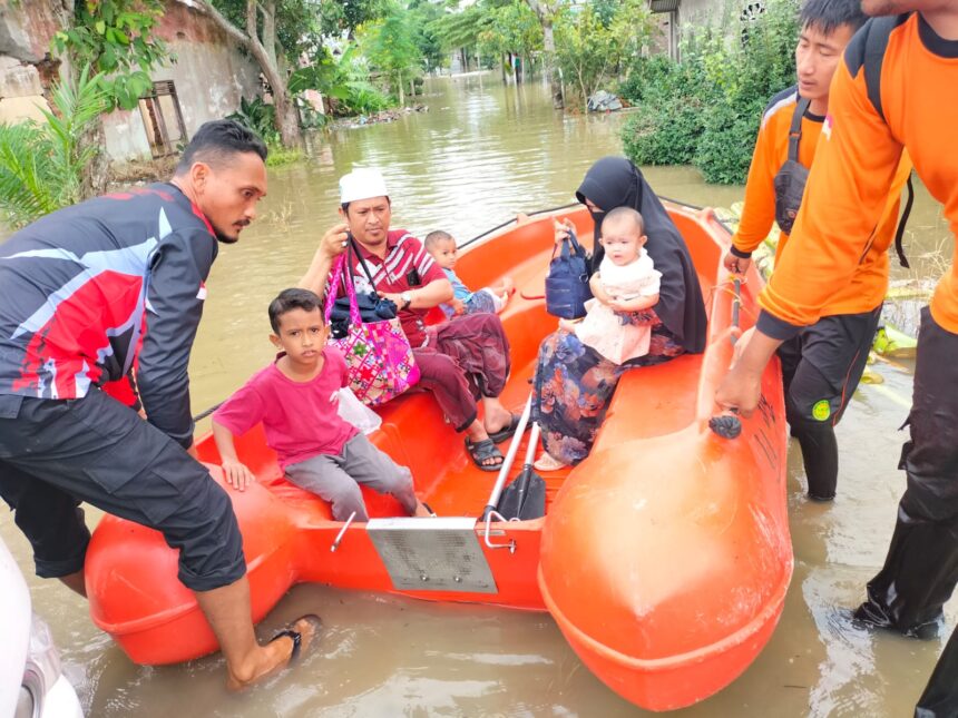 Tim BPBD Kabupaten Aceh Utara membantu proses evakuasi warga terdampak banjir di Kabupaten Aceh Utara, Kamis (28/12).