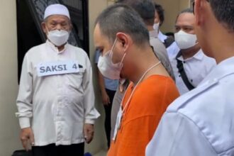 Tersangka Panca Darmansyah, 41, (baju tahanan orange) dihadirkan saat rekonstruksi 42 adegan pada kasus Kekerasan Dalam Rumah Tangga (KDRT) dan kasus pembunuhan 4 anaknya di unit kontrakan di Jagakarsa, Jakarta Selatan, pada Jumat (29/12).