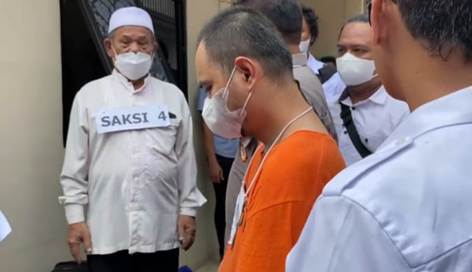 Tersangka Panca Darmansyah, 41, (baju tahanan orange) dihadirkan saat rekonstruksi 42 adegan pada kasus Kekerasan Dalam Rumah Tangga (KDRT) dan kasus pembunuhan 4 anaknya di unit kontrakan di Jagakarsa, Jakarta Selatan, pada Jumat (29/12).
