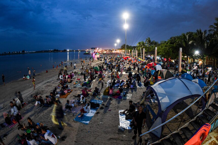 Sejumlah warga bermain saat menunggu malam pergantian tahun di Pantai Lagoon, Taman Impian Jaya Ancol, Jakarta, Minggu (31/12/2023) (Foto: Antara)
