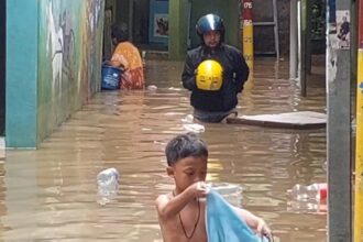 Aktivitas warga terganggu saat banjir merendam permukiman di kawasan Kebon Pala, RW 04 dan RW 05, Kampung Melayu, Jatinegara, Jakarta Timur, pada Senin (8/1). Foto: Joesvicar Iqbal/ipol.id