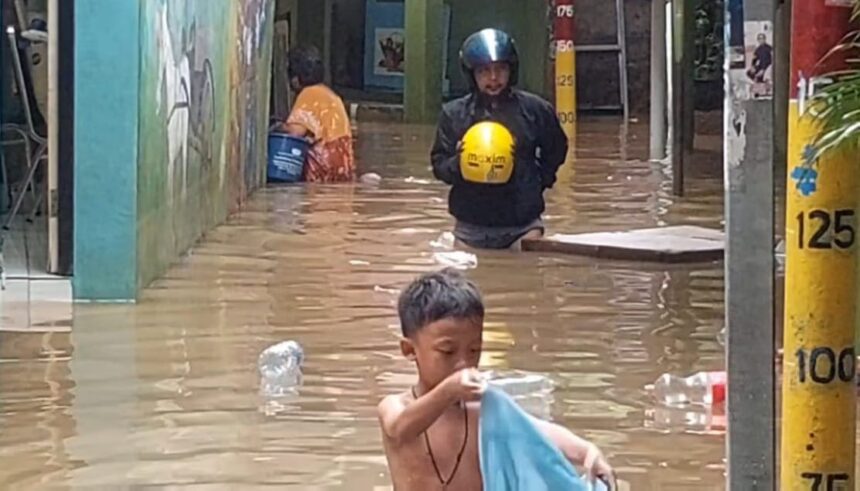 Aktivitas warga terganggu saat banjir merendam permukiman di kawasan Kebon Pala, RW 04 dan RW 05, Kampung Melayu, Jatinegara, Jakarta Timur, pada Senin (8/1). Foto: Joesvicar Iqbal/ipol.id