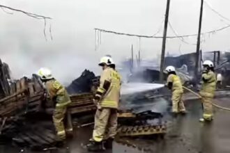 Sejumlah petugas Damkar berjibaku memadamkan api yang melumat lapak barang bekas seluas 250 meter persegi berisi tumpukan kayu di Jalan Raya Cakung Cilincing, Kelurahan Cakung Barat, Kecamatan Cakung, Jakarta Timur, pada Rabu (10/1). Foto: Ist