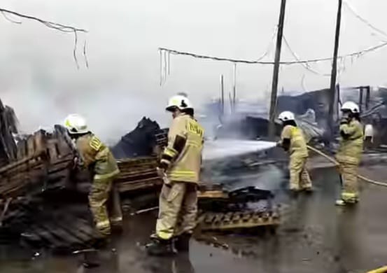 Sejumlah petugas Damkar berjibaku memadamkan api yang melumat lapak barang bekas seluas 250 meter persegi berisi tumpukan kayu di Jalan Raya Cakung Cilincing, Kelurahan Cakung Barat, Kecamatan Cakung, Jakarta Timur, pada Rabu (10/1). Foto: Ist