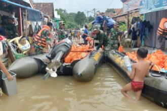 prajurit TNI AD melalui Kodim 0406/Lubuk Linggau di wilayah Korem 044/Gapo dengan sigap membantu mendistribusikan bantuan logistik kepada warga yang terdampak banjir pada Minggu (14/1/2024). Foto: Dispenad