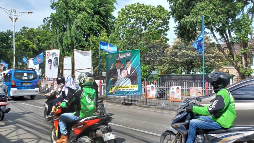 Alat Peraga Kampanye (APK) baliho caleg DPR RI pada salah satu tiang bambunya berdiri dengan kemiringan di bahu Jalan Raya Bogor, Kramat Jati, Jakarta Timur, Senin (22/1), dikhawatirkan membahayakan para pengguna jalan. Foto: Joesvicar Iqbal/ipol.id