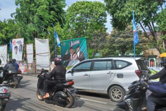 Sejumlah aparat Satuan Polisi Pamong Praja (Satpol PP) menertibkan ribuan alat peraga kampanye (APK) di sepanjang pagar median Jalan Raya Bogor, Kelurahan Kramat Jati, Kecamatan Kramat Jati, Jakarta Timur, Senin (29/1) siang. Foto: Joesvicar Iqbal/ipol.id