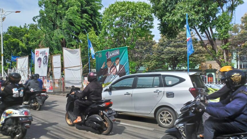 Sejumlah aparat Satuan Polisi Pamong Praja (Satpol PP) menertibkan ribuan alat peraga kampanye (APK) di sepanjang pagar median Jalan Raya Bogor, Kelurahan Kramat Jati, Kecamatan Kramat Jati, Jakarta Timur, Senin (29/1) siang. Foto: Joesvicar Iqbal/ipol.id