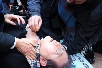 Lee Jae-myung, pemimpin oposisi utama Partai Demokrat, berbaring setelah diserang oleh penyerang di sisi kiri lehernya saat berkunjung ke lokasi pembangunan bandara di Pulau Gadeok di lepas pantai tenggara kota pelabuhan Busan pada 2 Januari 2024. Foto: Yonhap