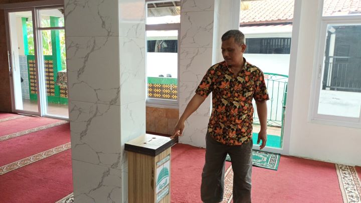 Ketua DKM Musala Ar-Rohmah, Subagyo pada Sabtu (27/1), menunjukkan kotak amal yang duitnya sempat digasak pelaku pencuri di kawasan Pasar Rebo, Jakarta Timur, belum lama ini. Foto: Ist