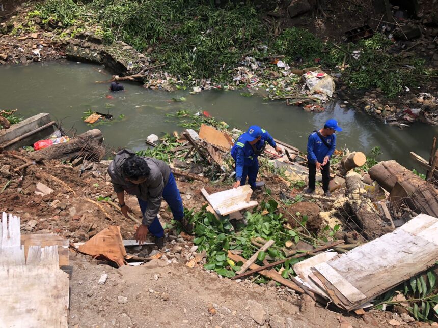 Sejumlah petugas Sudin Sumber Daya Air (SDA) berupaya menangani material longsor di tebing di kawasan RT 02 RW 04, Kelurahan Cipinang, Kecamatan Pulogadung, Jakarta Timur, Selasa (13/2) siang. Foto: Ist