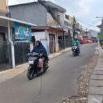 Suasana sejumlah pengguna jalan pengendara sepeda motor menghindari kabel yang menjuntai di Jalan Cibubur II, Blok Dukuh, Kelurahan Cibubur, Kecamatan Ciracas, Jakarta Timur, Selasa (20/2) siang. Foto: Joesvicar Iqbal/ipol.id