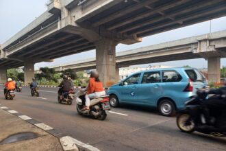 Sejumlah pengendara sepeda motor melintasi Jalan Raya Kalimalang, Duren Sawit, Jakarta Timur, Rabu (21/2). Foto: Joesvicar Iqbal/ipol.id
