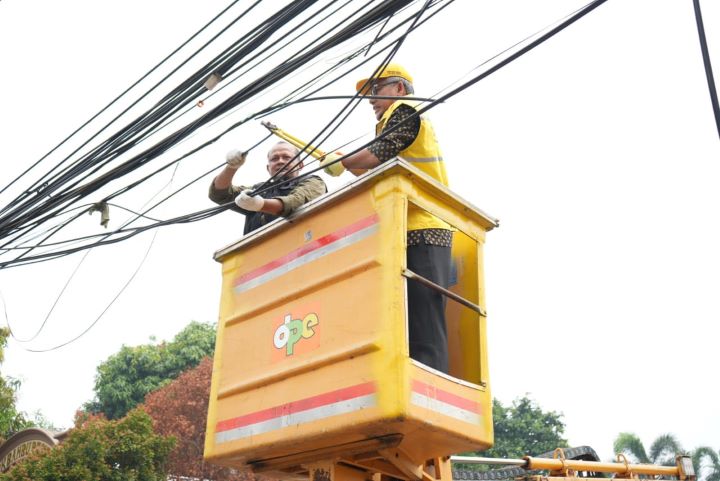 Satgas kuning saat menertibkan kabel udara di kawasan Pondok Bambu, Duren Sawit, Jakarta Timur, beberapa waktu lalu. Foto: Ist