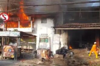 Suasana warga sekitar berupaya memadamkan kios bengkel penjual bensin eceran yang kebakaran di Jalan Kayu Manis 9, Matraman, Jakarta Timur, pada Jumat (9/2) pagi. Foto: Joesvicar Iqbal/ipol.id