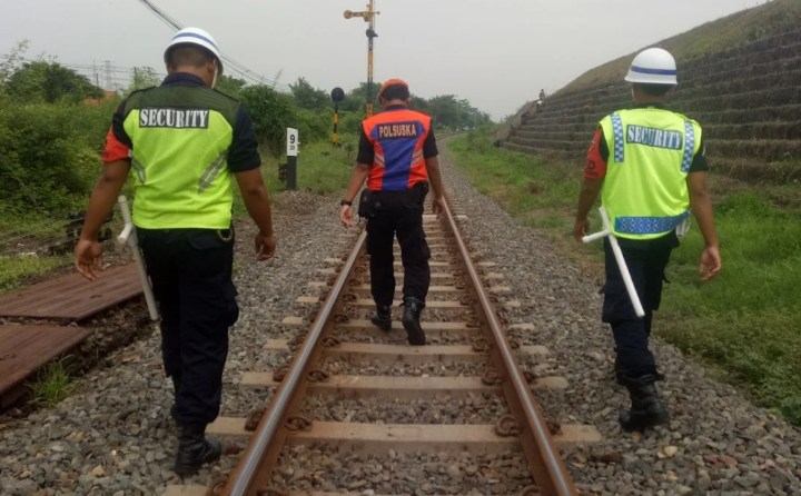 Petugas PT Kereta Api Indonesia (Persero) berpatroli menyusuri jalur kereta api. Foto: KAI