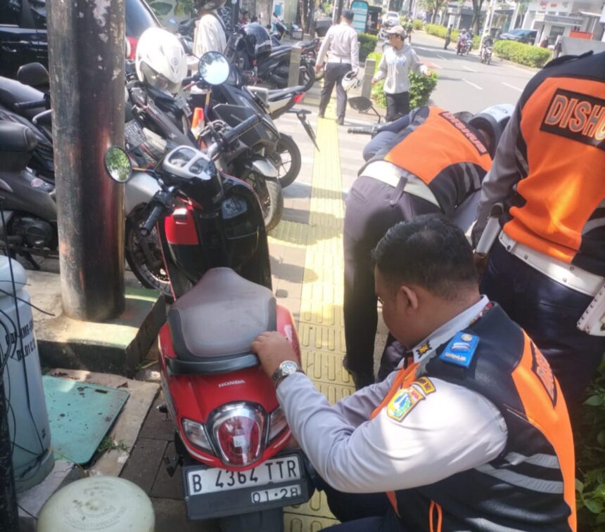 Sejumlah aparat Sudinhub Jakarta Selatan melakukan cabut pentil motor yang kedapatan parkir sembarang tempat dan Satuan Polisi Pamong Praja (Satpol PP) menertibkan pedagang kaki lima yang mengokupasi trotoar di sepanjang Jalan Kemang Raya, Mampang Prapatan, Selasa (5/3) siang. Foto: Ist