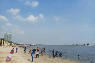 Suasana sejumlah pengunjung bermain pasir di tepi pantai Ancol Taman Impian. Foto: Joesvicar Iqbal/Dok/ipol.id