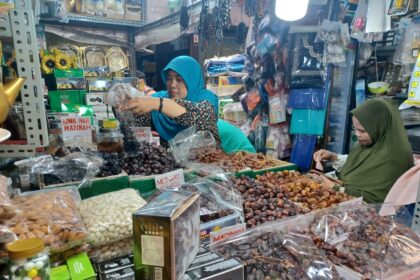 Pedagang kurma, Elawati, 52, sedang melayani Ibu-Ibu pembeli kurma di tokonya di Pasar Jatinegara di Jalan Pasar Utara, Jatinegara, Jakarta Timur, Senin (11/3) siang. Foto: Joesvicar Iqbal/ipol.id