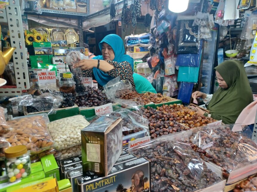 Pedagang kurma, Elawati, 52, sedang melayani Ibu-Ibu pembeli kurma di tokonya di Pasar Jatinegara di Jalan Pasar Utara, Jatinegara, Jakarta Timur, Senin (11/3) siang. Foto: Joesvicar Iqbal/ipol.id