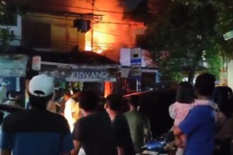 Suasana saat warga sekitar menyaksikan gerai restoran makanan siap saji di Jalan Haji Naman, Kelurahan Pondok Kelapa, Kecamatan Duren Sawit, Jakarta Timur, kebakaran pada Selasa (12/3) malam. Foto: Ist