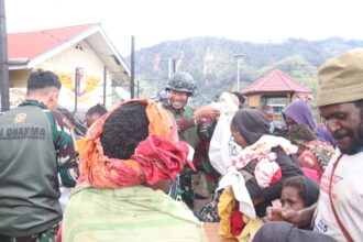 Ksatria Tri Dharma membagikan baju layak pakai kepada masyarakat Intan Jaya, di halaman Pos Japugau Janambani (J2), Intan Jaya, Papua Tengah, Kamis (14/3/2024). Foto: Satgas Pamtas Mobile Yonif 330 Tri Dharma Kostrad