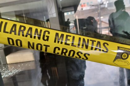 Aparat polisi memasang garis police line di tempat kejadian perkara (TKP) penembakan yang diduga dilakukan pelaku Gathan di perkantoran di kawasan Jatinegara, Jakarta Timur, belum lama ini. Foto: Dok/ipol.id