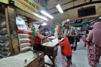 Pedagang beras, Slamet, 48, saat melayani pembeli beras ketan dan ketan hitam di losnya di Pasar Ciracas, Kelurahan/Kecamatan Ciracas, Jakarta Timur, Rabu (13/3). Foto: Joesvicar Iqbal/ipol.id