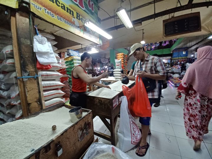 Pedagang beras, Slamet, 48, saat melayani pembeli beras ketan dan ketan hitam di losnya di Pasar Ciracas, Kelurahan/Kecamatan Ciracas, Jakarta Timur, Rabu (13/3). Foto: Joesvicar Iqbal/ipol.id