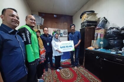 Kepala Kantor Wilayah (Kakanwil) BPJS Ketenagakerjaan DKI Jakarta, Deny Yusyulian, Kepala Kantor Cabang BPJS Ketenagakerjaan (TK) Jakarta Kebayoran Baru, Husaini, Deputi Kepesertaan Program Khusus dan Keagenan BPJS TK, I Putu Wiradana, perwakilan Manajemen Gojek serta Direktur Jaminan Sosial Tenaga Kerja Kementerian Ketenagakerjaan RI, Retno Pratiwi saat penyerahan bantuan pemberian manfaat biaya pengobatan dan perawatan ke peserta BPJS TK mitra Gojek, Bambang Supriyono, 37, di Jl. Kemandoran VIII, Gang Keranti, RT 10/11, Grogol Utara, Kebayoran Lama, Jakarta Selatan, Selasa (19/3) sore. Foto: Joesvicar Iqbal/ipol.id