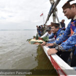 Pj Bupati Pasuruan saat melarung tumpeng ke laut bersama masyarakat. Foto:Kominfo Kab Pasuruan