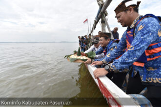 Pj Bupati Pasuruan saat melarung tumpeng ke laut bersama masyarakat. Foto:Kominfo Kab Pasuruan